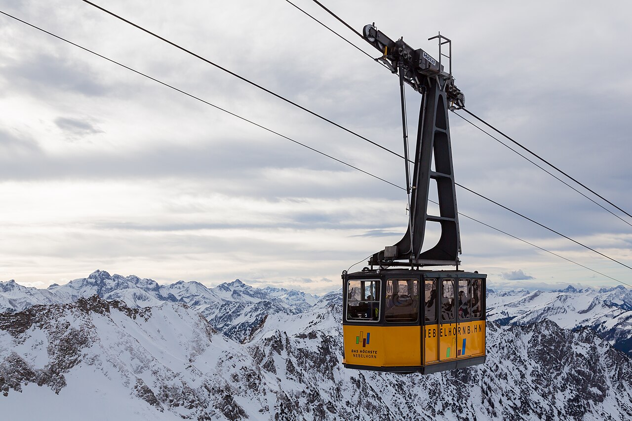 Gondel der Nebelhornbahn vor verschneiten Gipfeln