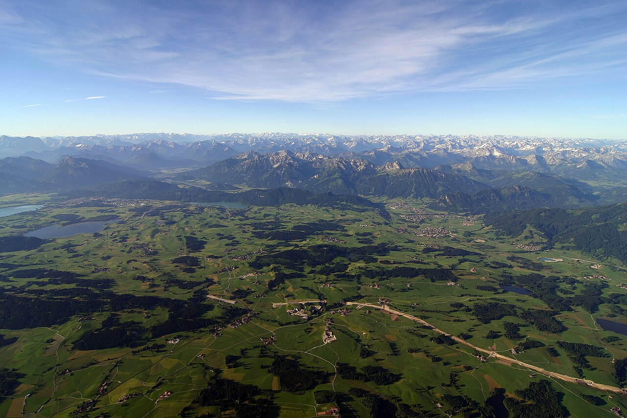 Luftbild der Allgäuer Voralpen mit Seen und den Alpen im Hintergrund