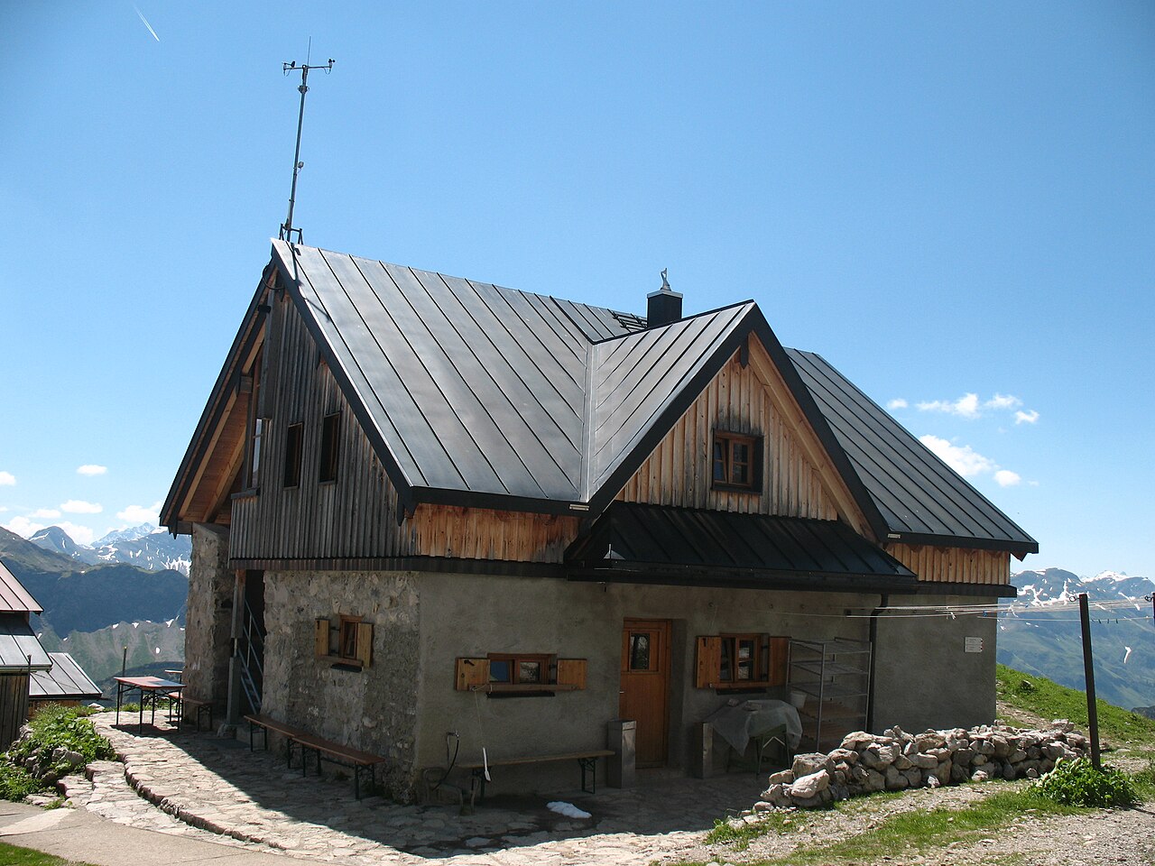 Kleines Berghaus mit Steinsockel und Holzgiebel in den Bergen